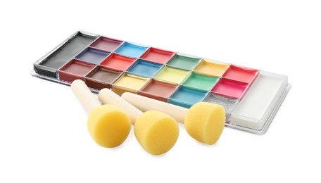 Photo of Bright face paint palette and sponges isolated on white