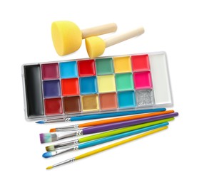 Photo of Bright face paint palette, brushes and sponges isolated on white, top view