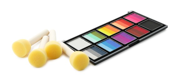 Photo of Bright face paint palette and sponges isolated on white