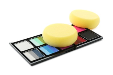 Photo of Bright face paint palette and sponges isolated on white