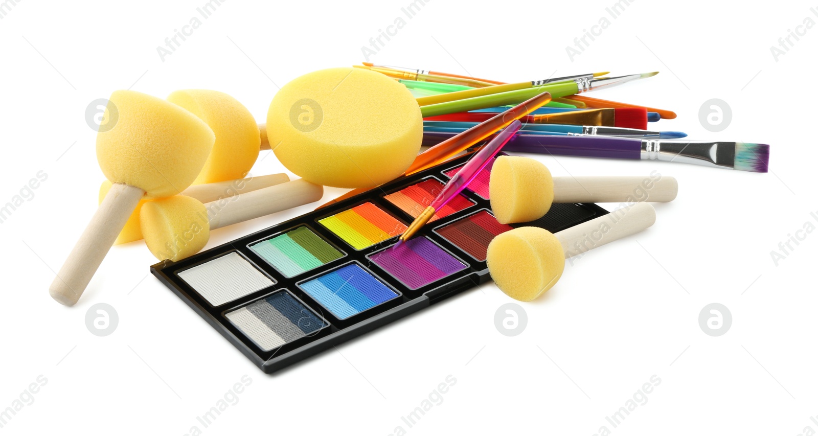 Photo of Bright face paint palette, brushes and sponges isolated on white