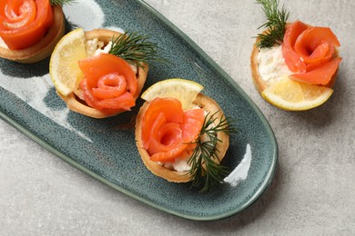 Photo of Tasty tartlets with delicious filling on grey table, flat lay