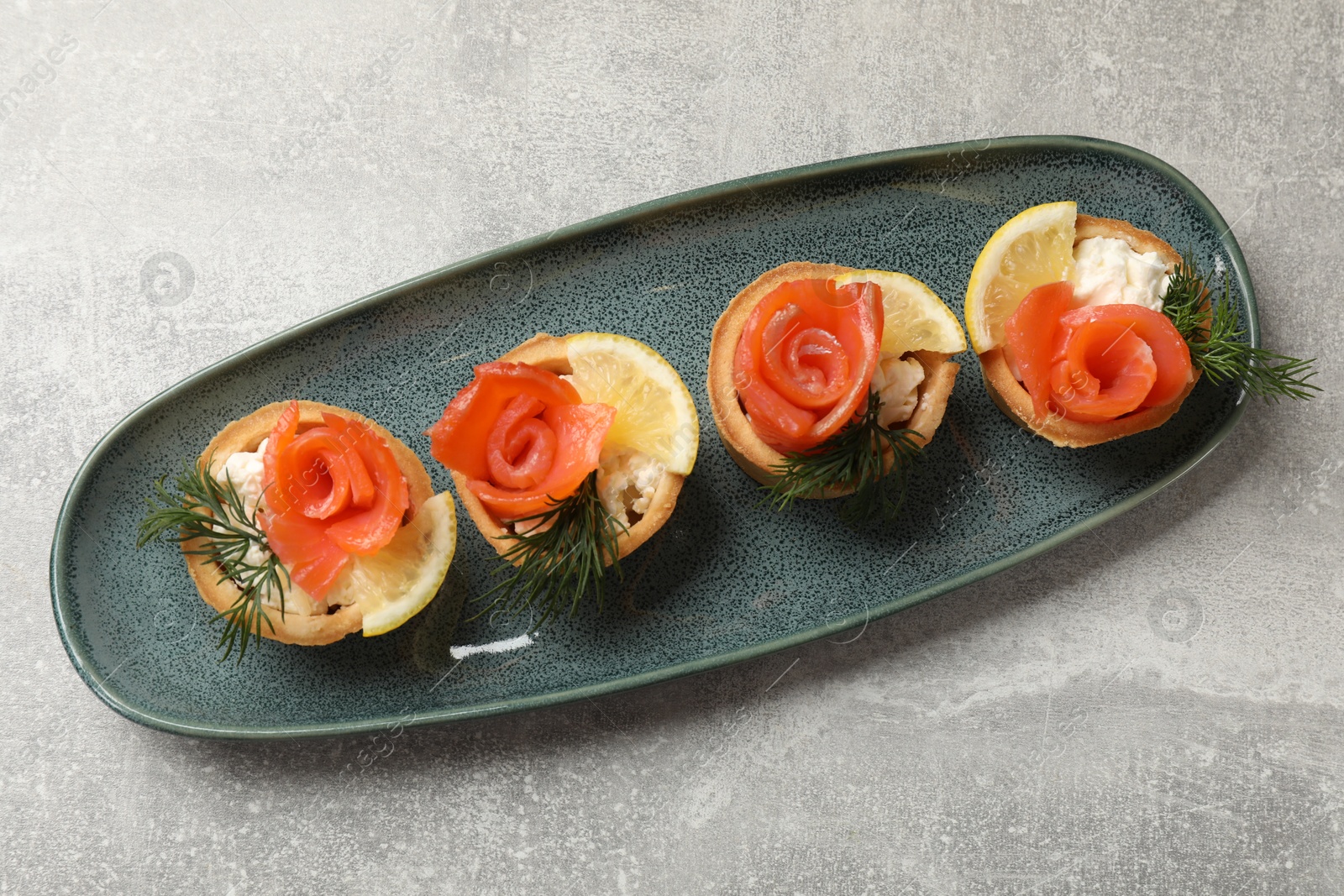 Photo of Tasty tartlets with delicious filling on grey table, top view