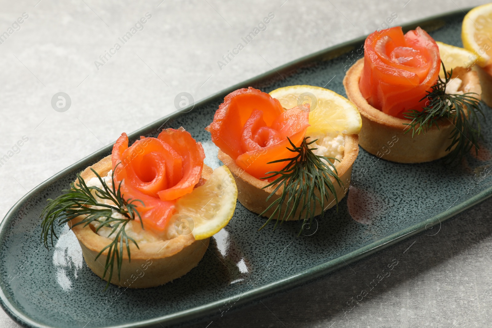 Photo of Tasty tartlets with delicious filling on grey table, closeup