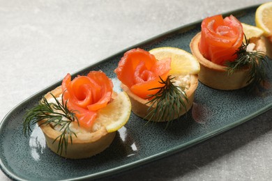 Photo of Tasty tartlets with delicious filling on grey table, closeup