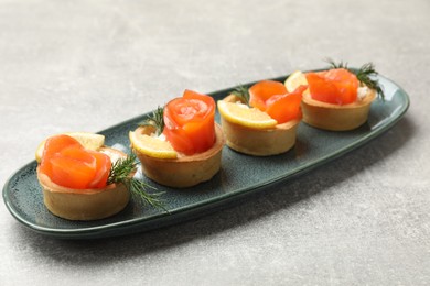 Photo of Tasty tartlets with delicious filling on grey table, closeup