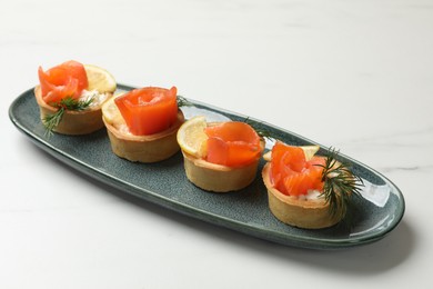 Photo of Tasty tartlets with delicious filling on white marble table, closeup