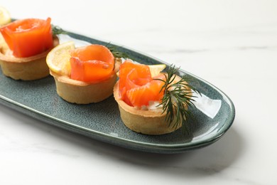 Photo of Tasty tartlets with delicious filling on white marble table, closeup