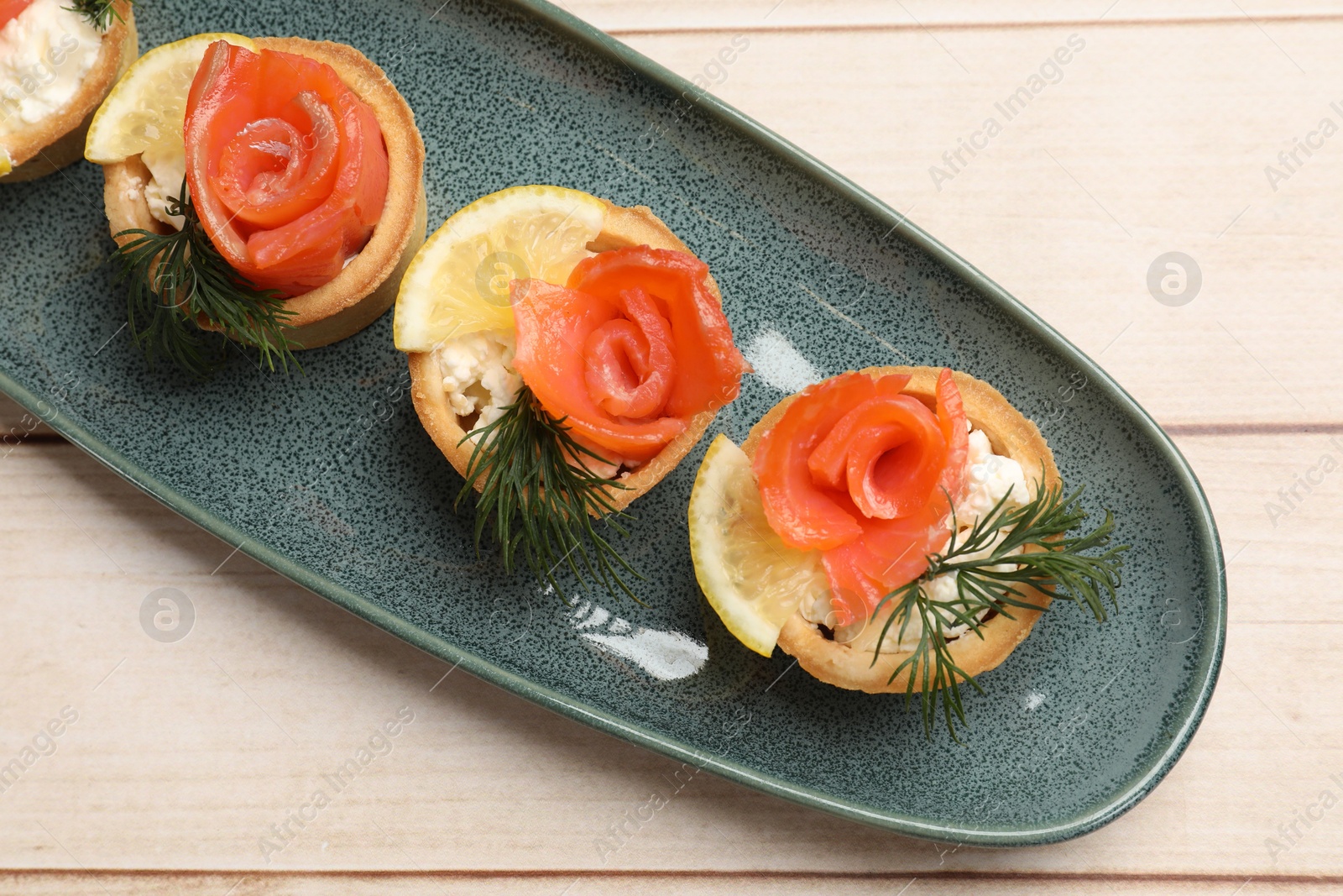 Photo of Tasty tartlets with delicious filling on wooden table, top view