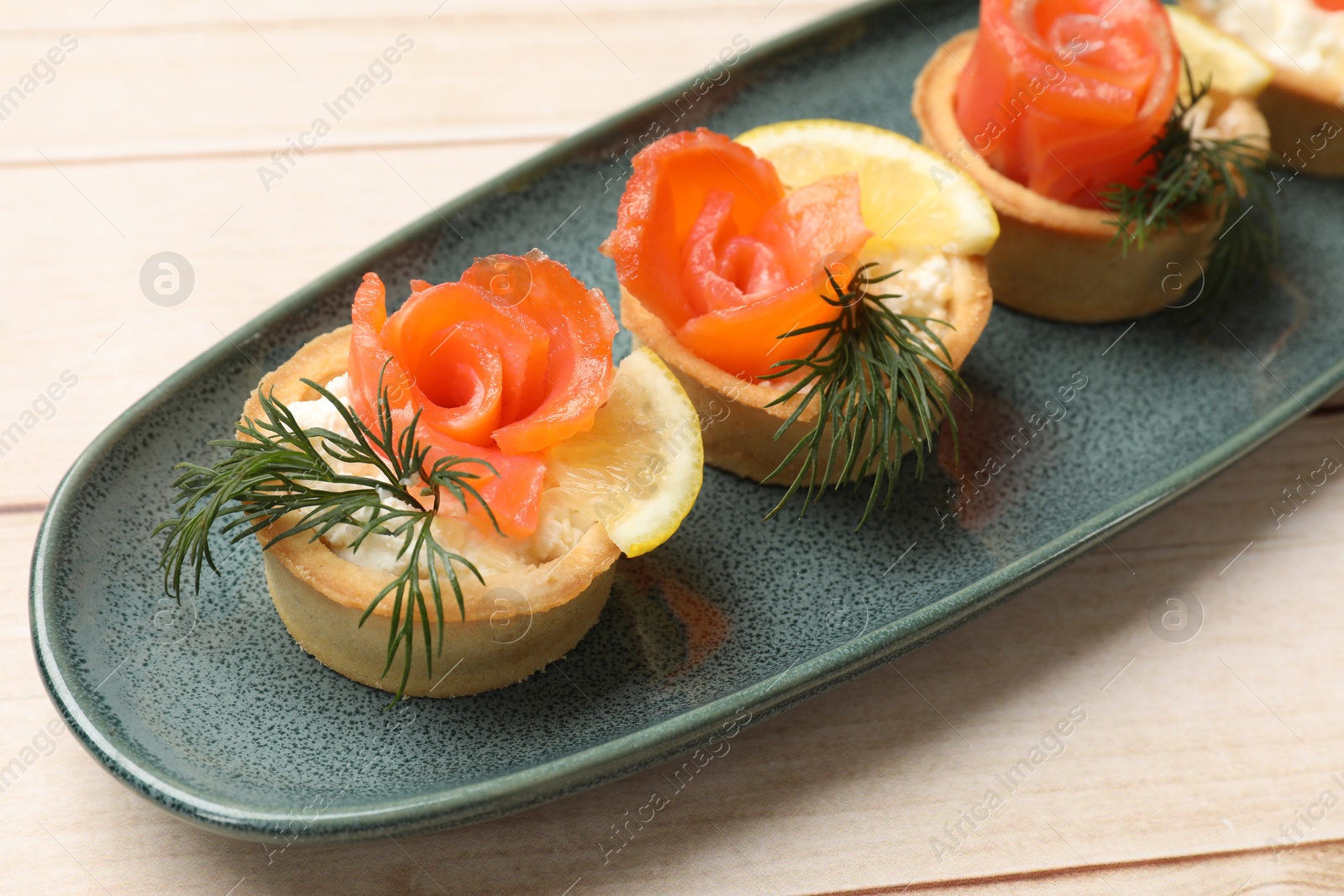 Photo of Tasty tartlets with delicious filling on wooden table, closeup