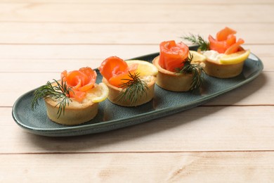 Photo of Tasty tartlets with delicious filling on wooden table, closeup