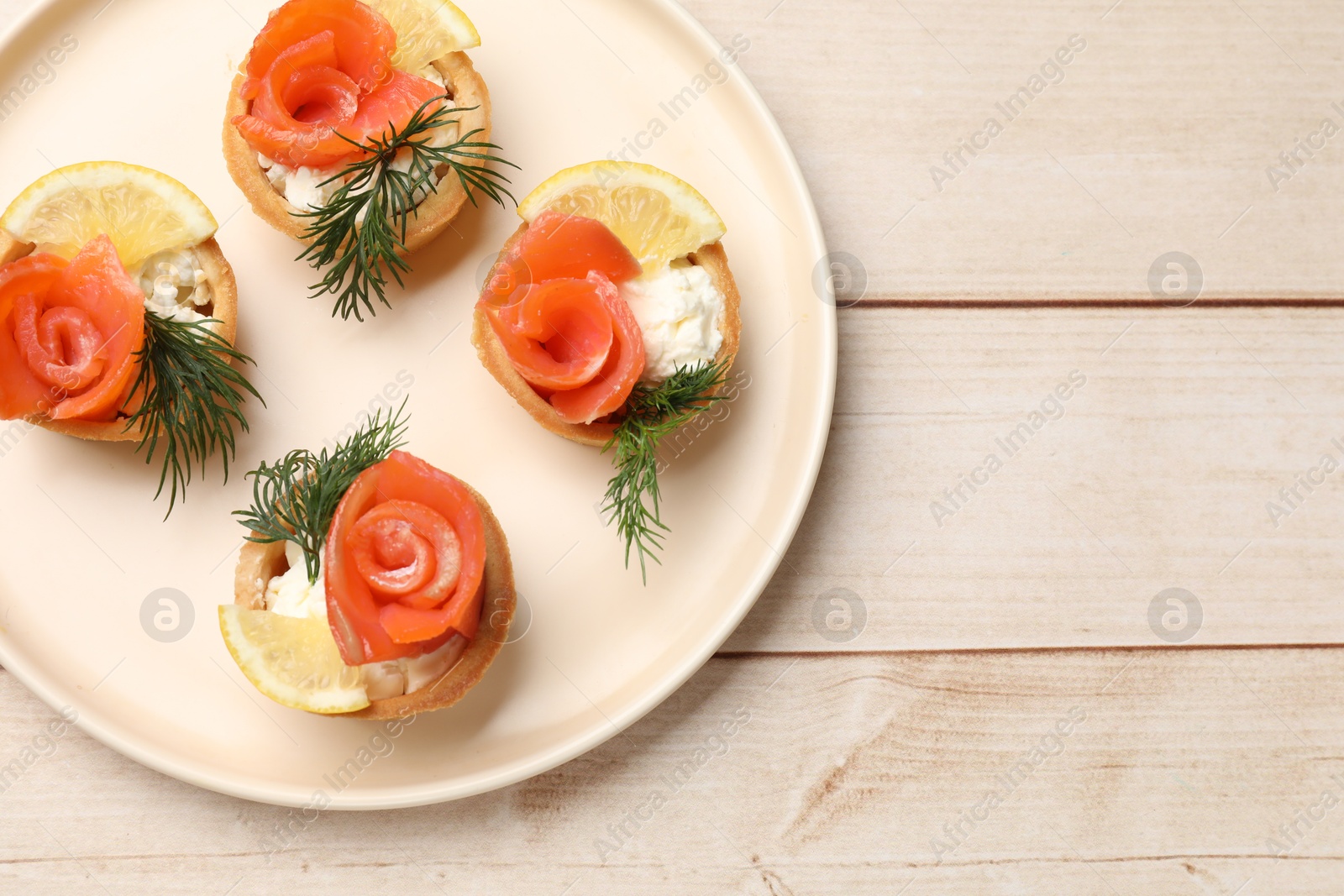 Photo of Tasty tartlets with delicious filling on wooden table, top view. Space for text