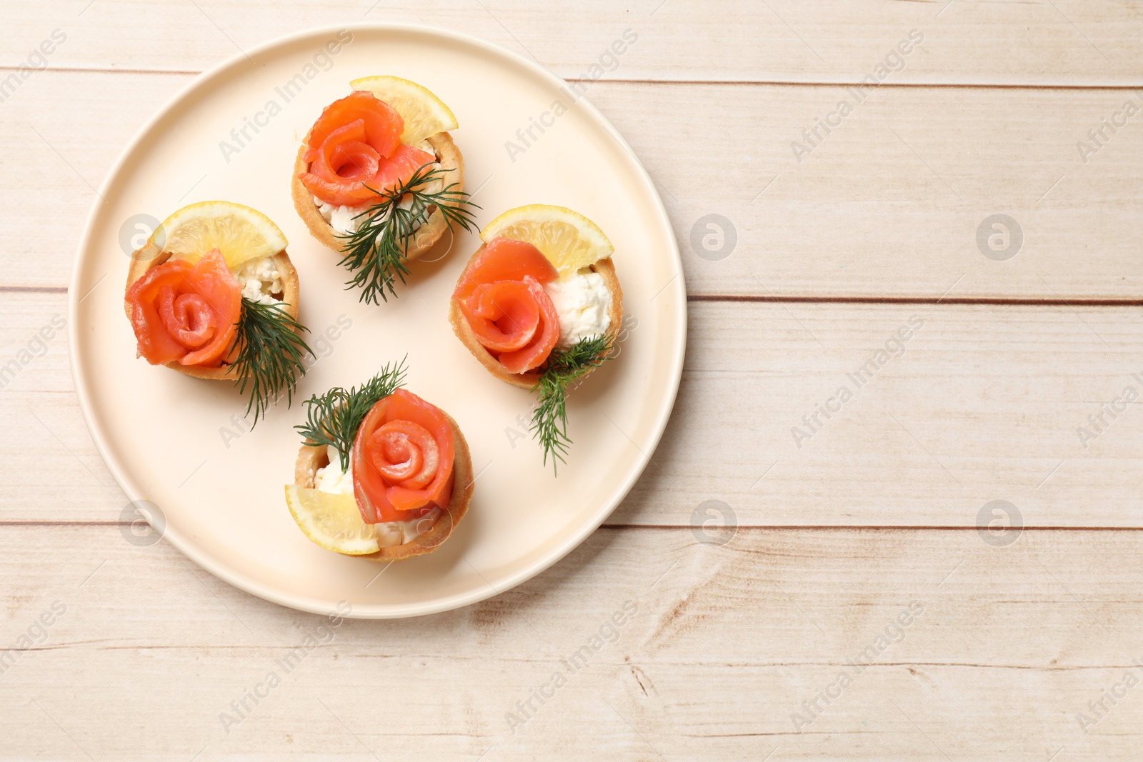 Photo of Tasty tartlets with delicious filling on wooden table, top view. Space for text