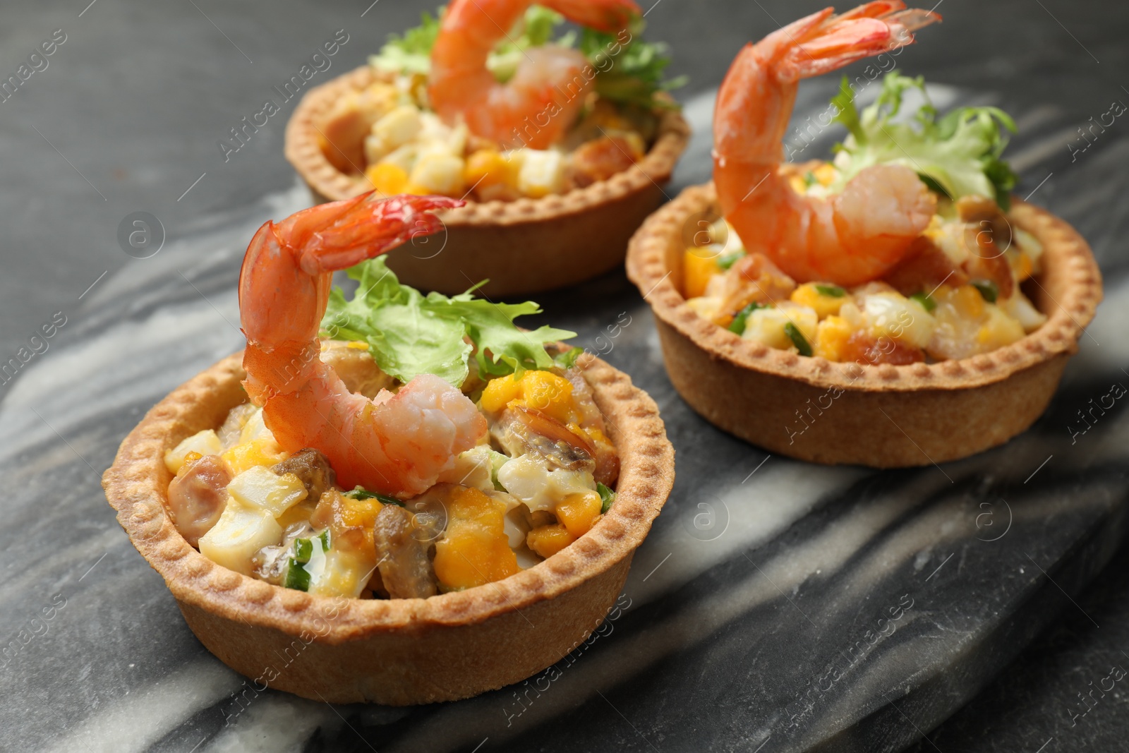 Photo of Tartlets with delicious filling on table, closeup