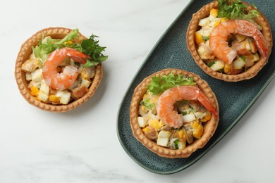 Photo of Tartlets with delicious filling on white marble table, flat lay