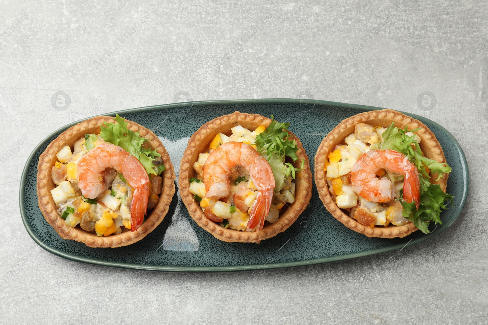 Photo of Tartlets with delicious filling on grey table, top view