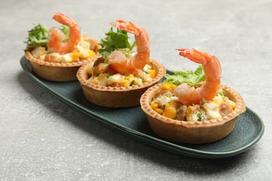 Photo of Tartlets with delicious filling on grey table, closeup