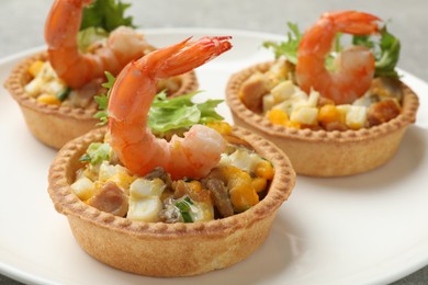 Photo of Tartlets with delicious filling on plate, closeup