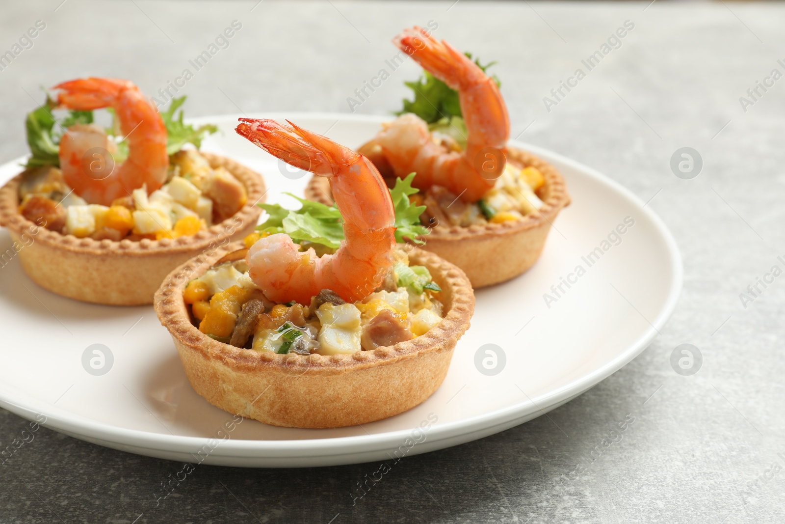 Photo of Tartlets with delicious filling on grey table, closeup