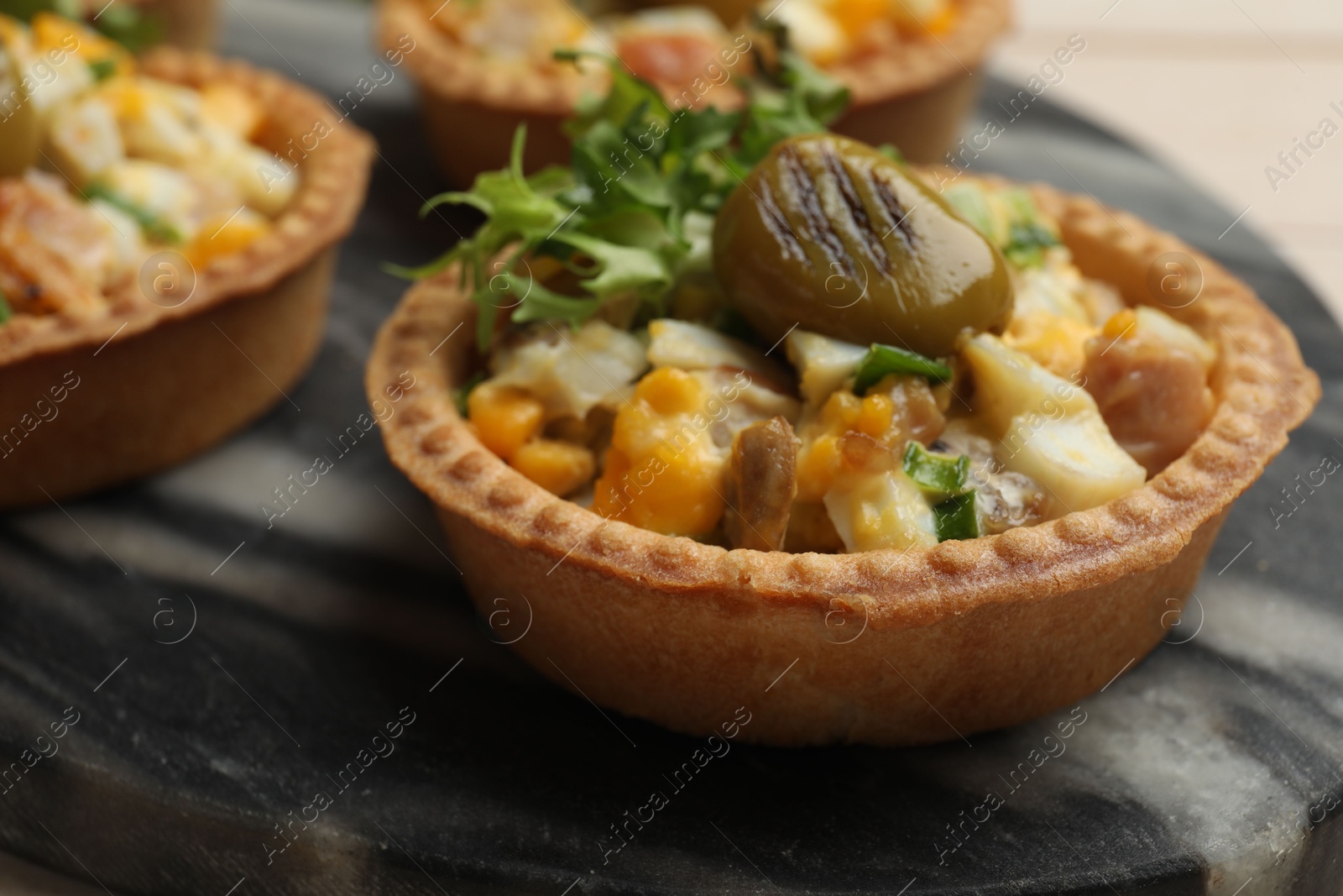 Photo of Tartlets with delicious filling on table, closeup