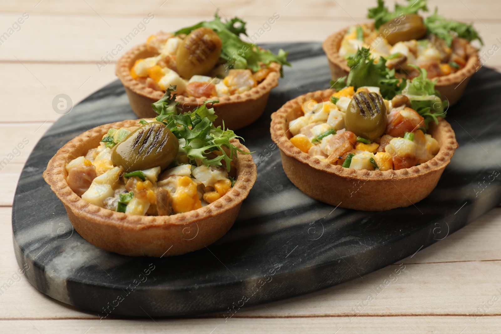 Photo of Tartlets with delicious filling on wooden table, closeup