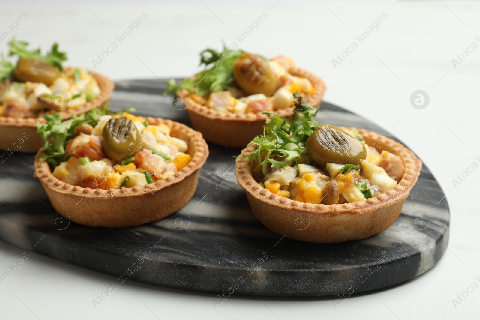 Photo of Tartlets with delicious filling on white table, closeup