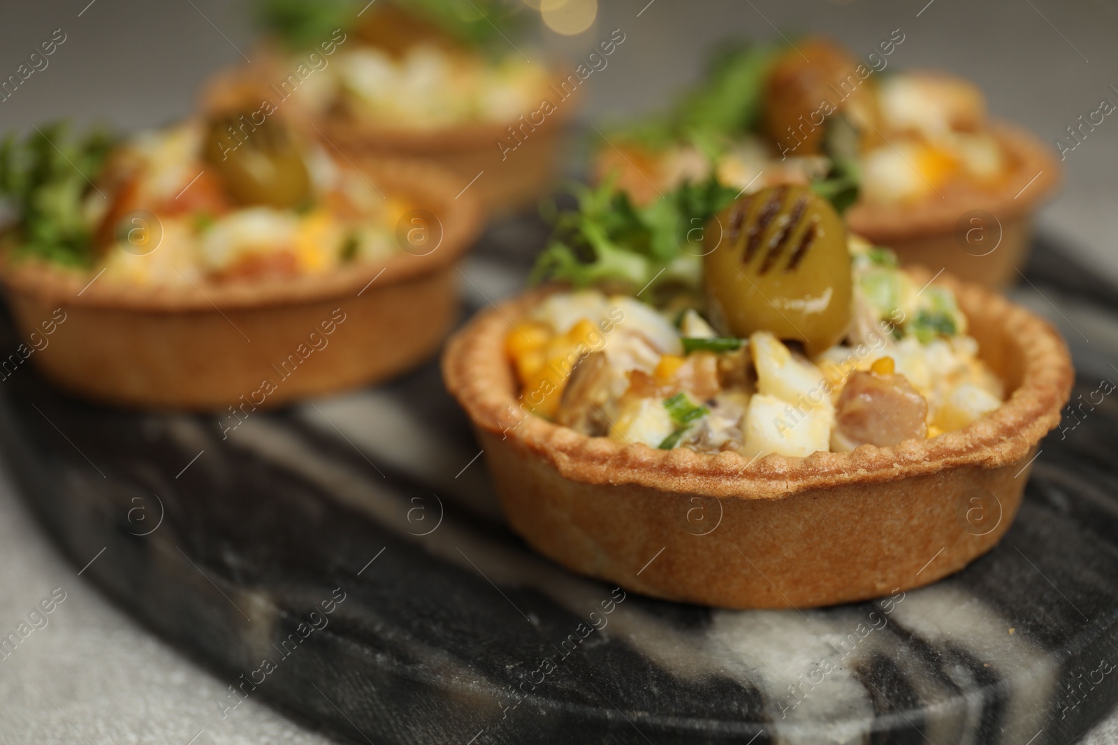 Photo of Tartlets with delicious filling on table, closeup