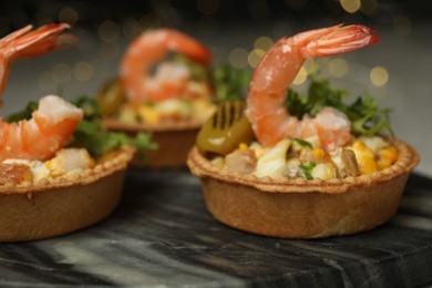 Photo of Tartlets with delicious filling on table, closeup. Bokeh effect