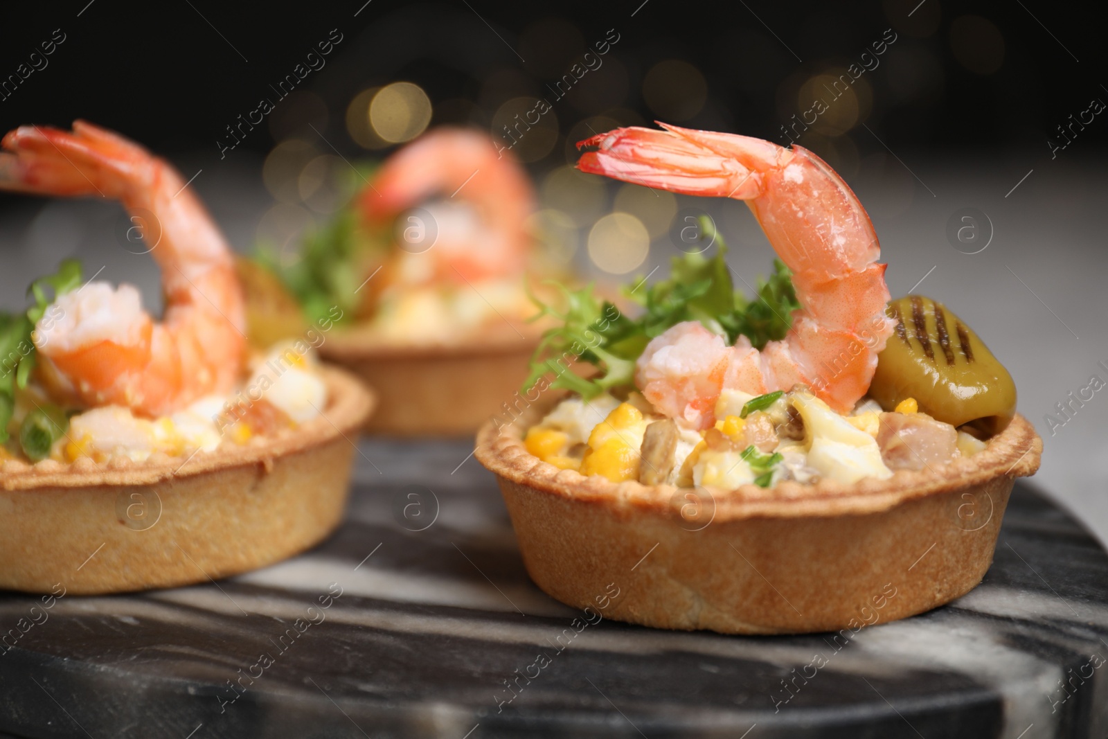 Photo of Tartlets with delicious filling on table, closeup. Bokeh effect