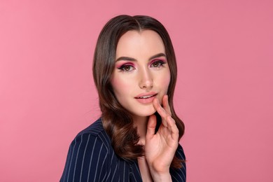 Photo of Portrait of beautiful young woman with stylish makeup and gorgeous hair on pink background