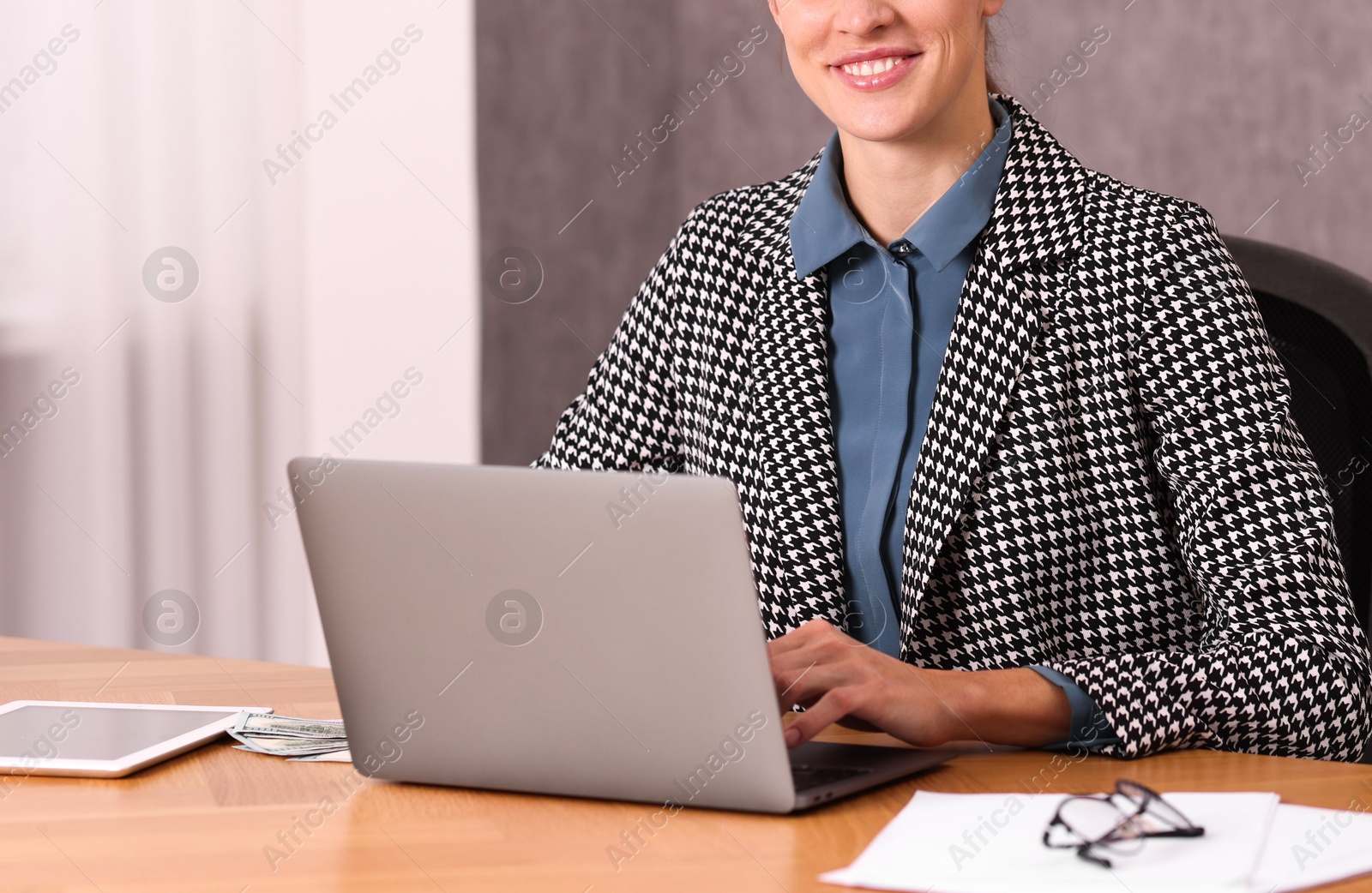 Photo of Banker working with laptop at wooden table in office