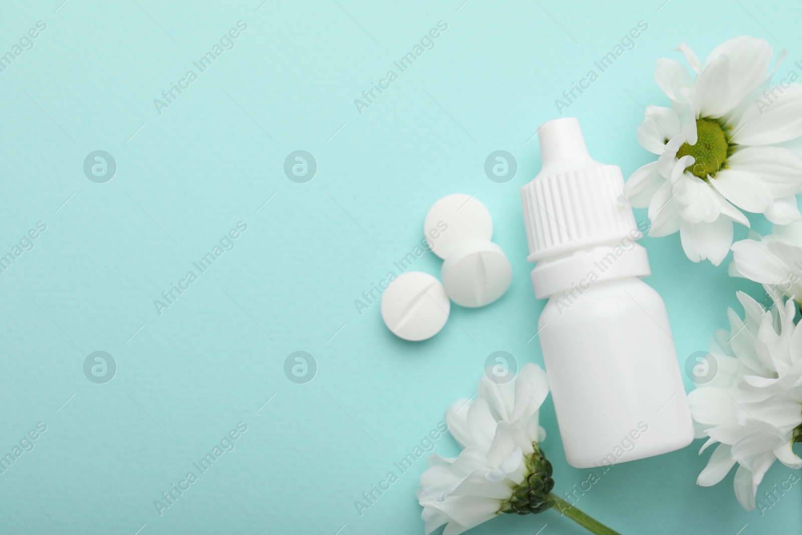 Photo of Allergy treatment. Nasal drops, pills and flowers on light blue background, flat lay. Space for text