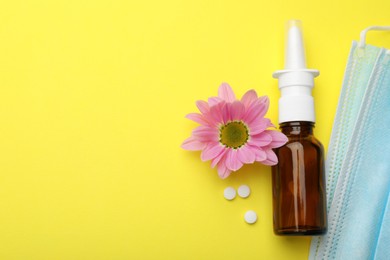 Photo of Allergy treatment. Nasal spray, pills, protective masks and flower on yellow background, flat lay. Space for text