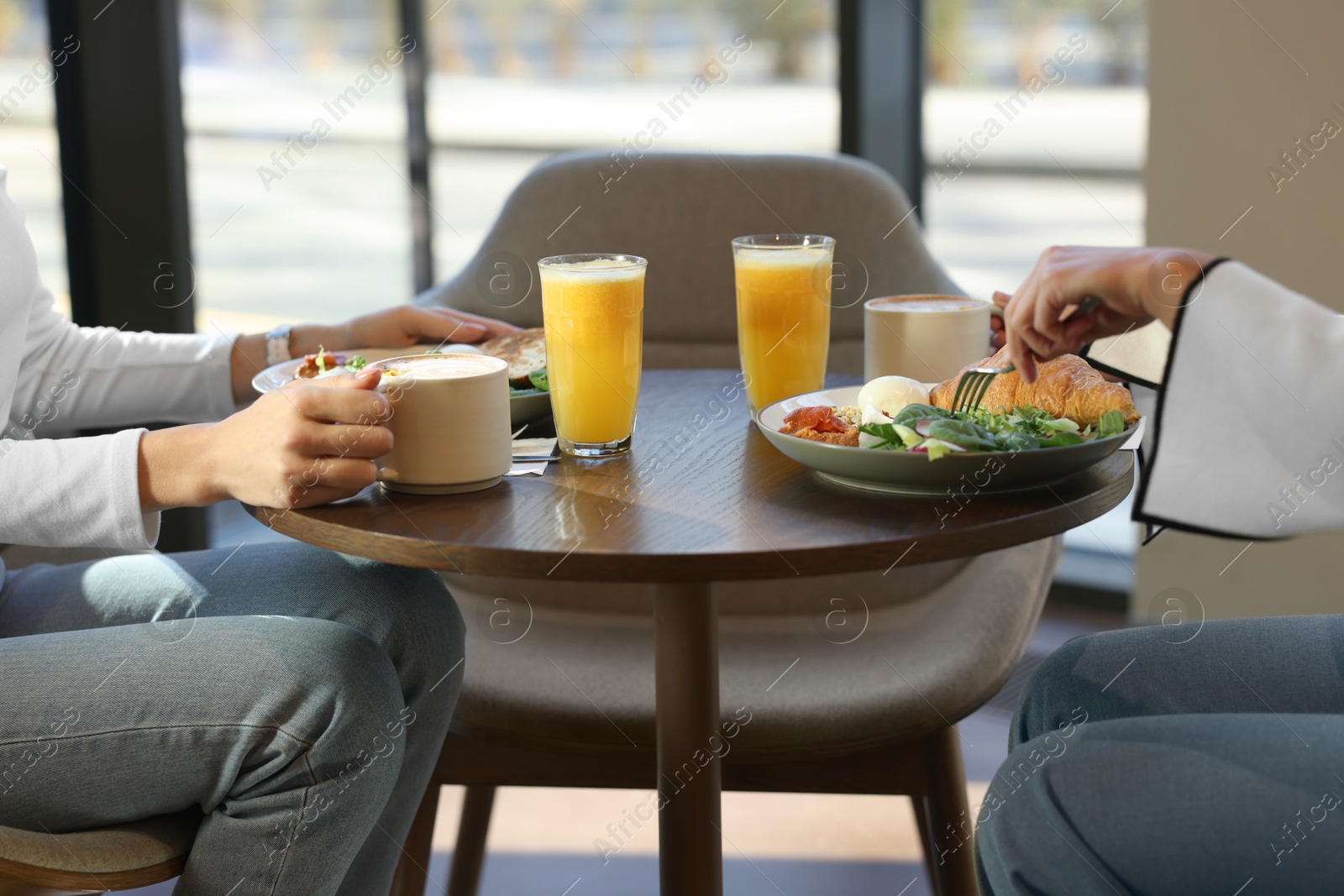 Photo of Women having tasty breakfast in cafe, closeup