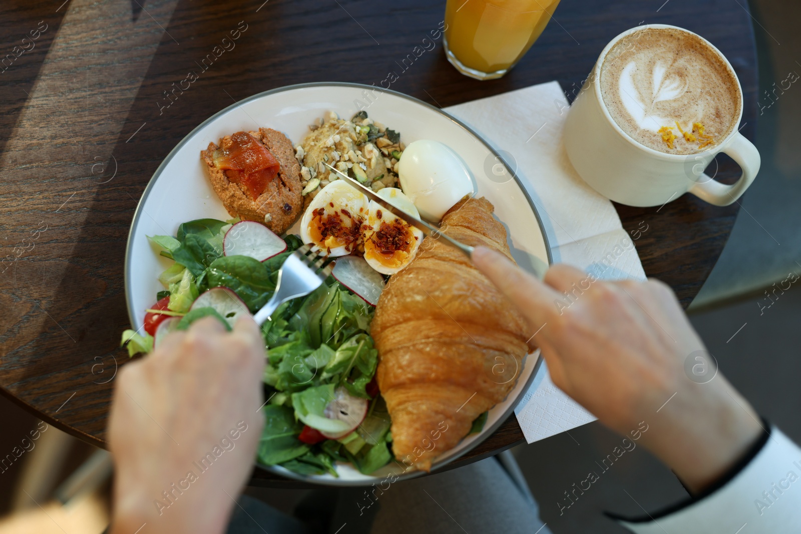 Photo of Woman having tasty breakfast in cafe, top view