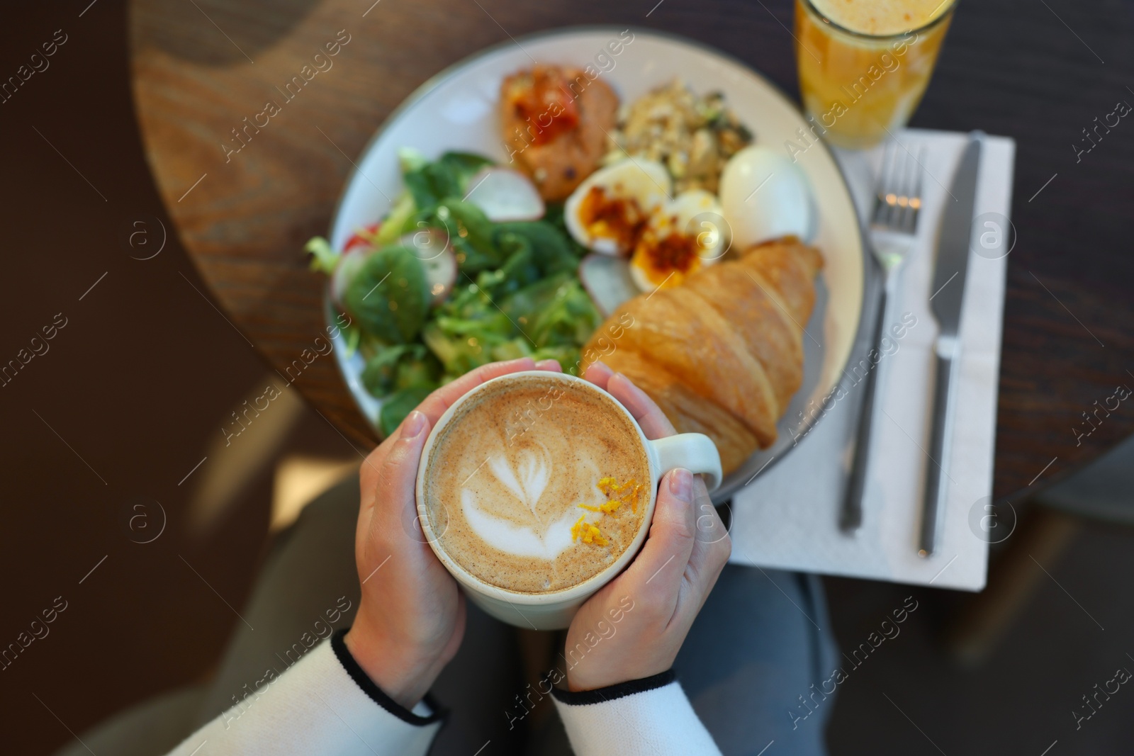 Photo of Woman having tasty breakfast in cafe, top view