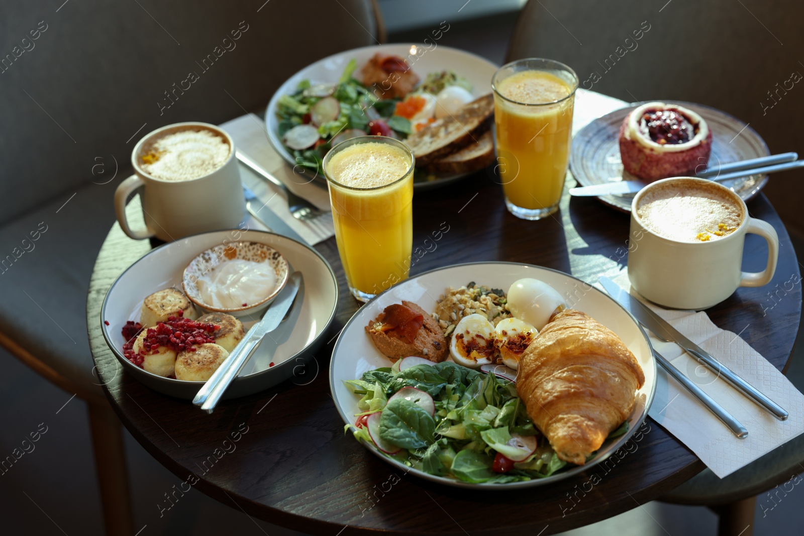 Photo of Tasty breakfast. Different meals and drinks served on wooden table in cafe