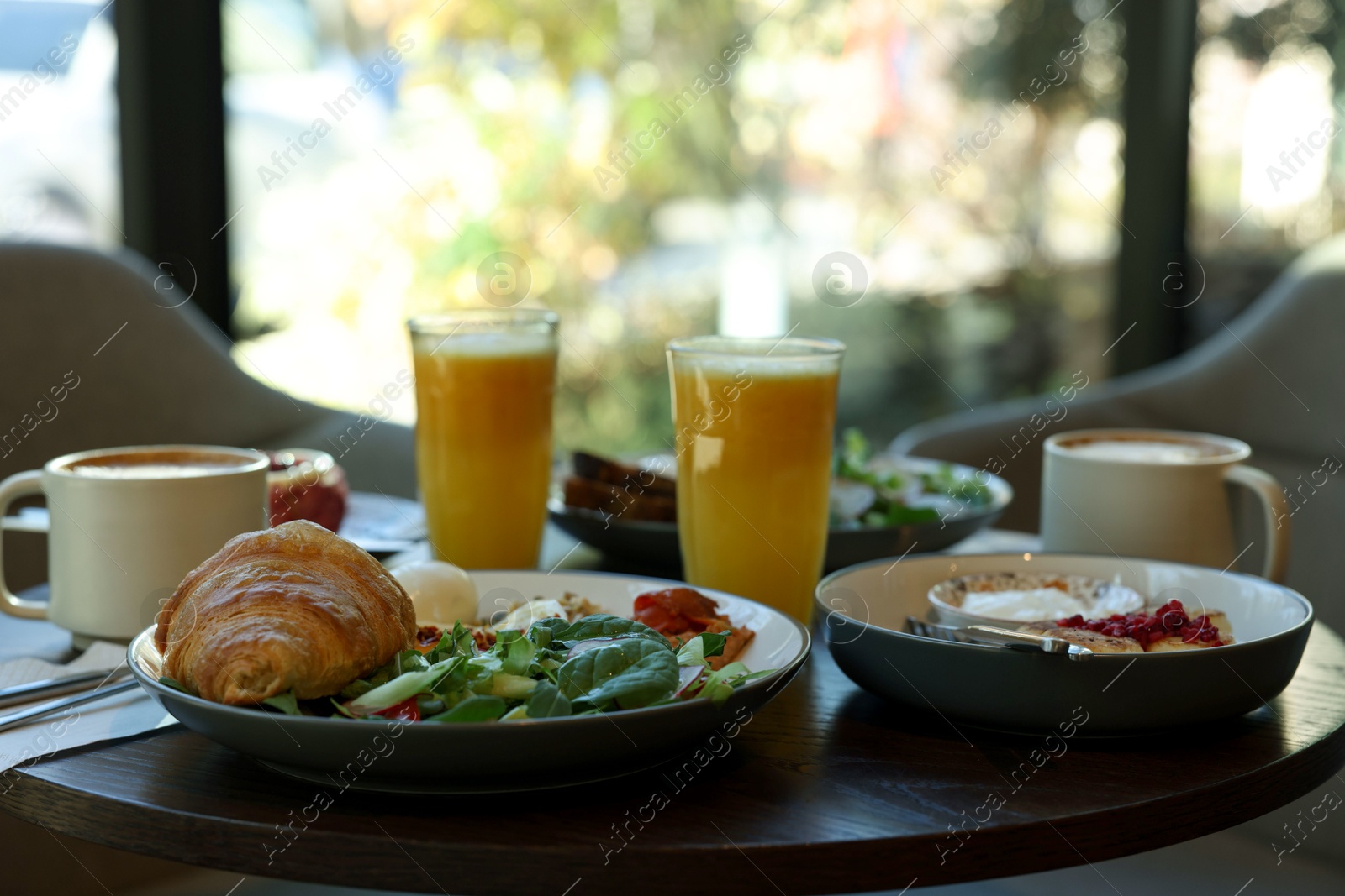 Photo of Tasty breakfast. Different meals and drinks served on wooden table in cafe