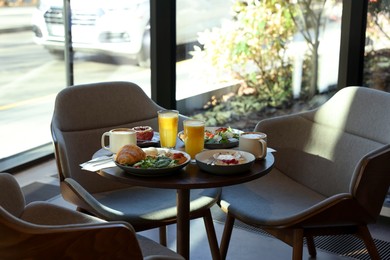 Photo of Tasty breakfast. Different meals and drinks served on wooden table in cafe