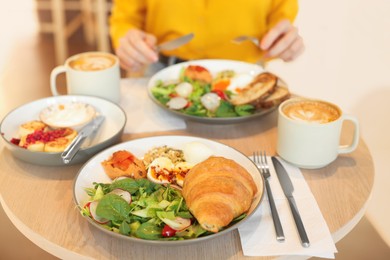 Photo of Woman having tasty breakfast in cafe, closeup