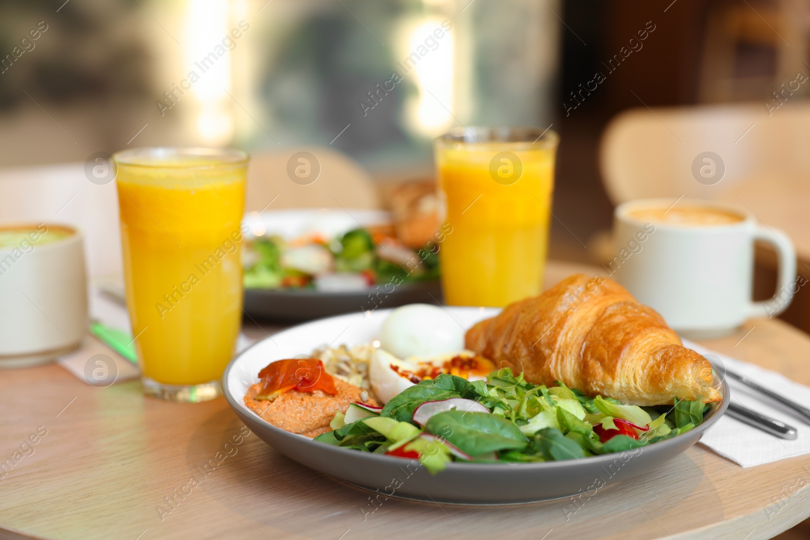 Photo of Tasty breakfast. Different meals and drinks served on wooden table in cafe, closeup