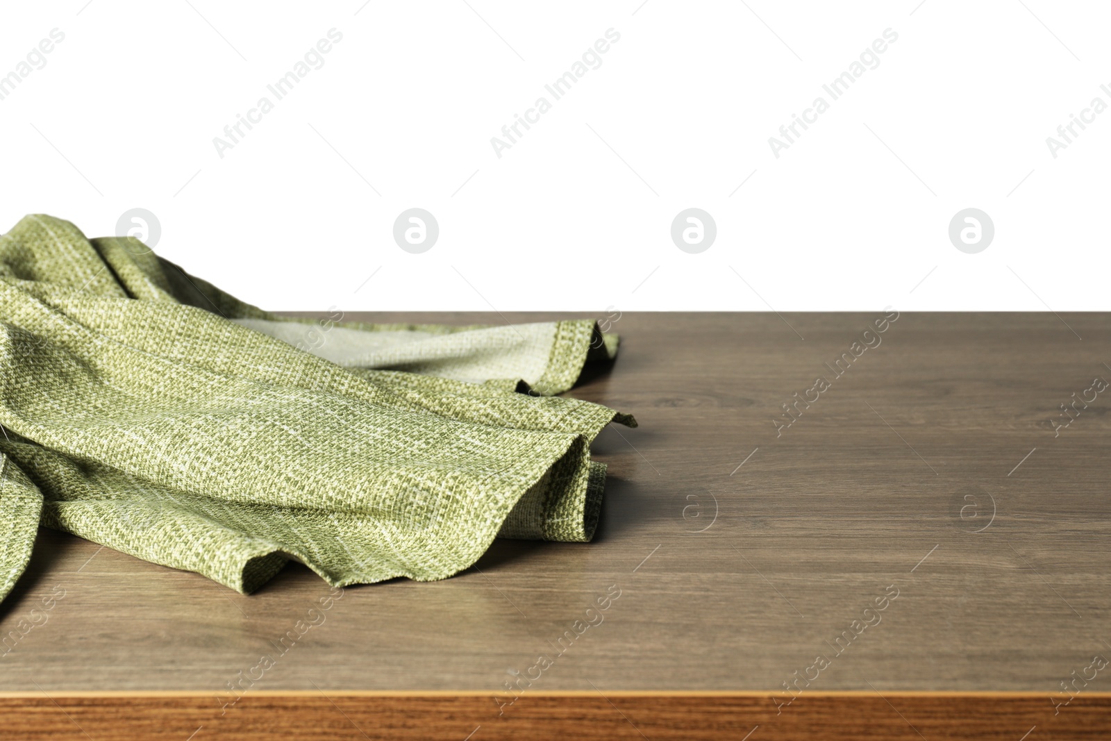 Photo of Green tablecloth on wooden table against white background, closeup