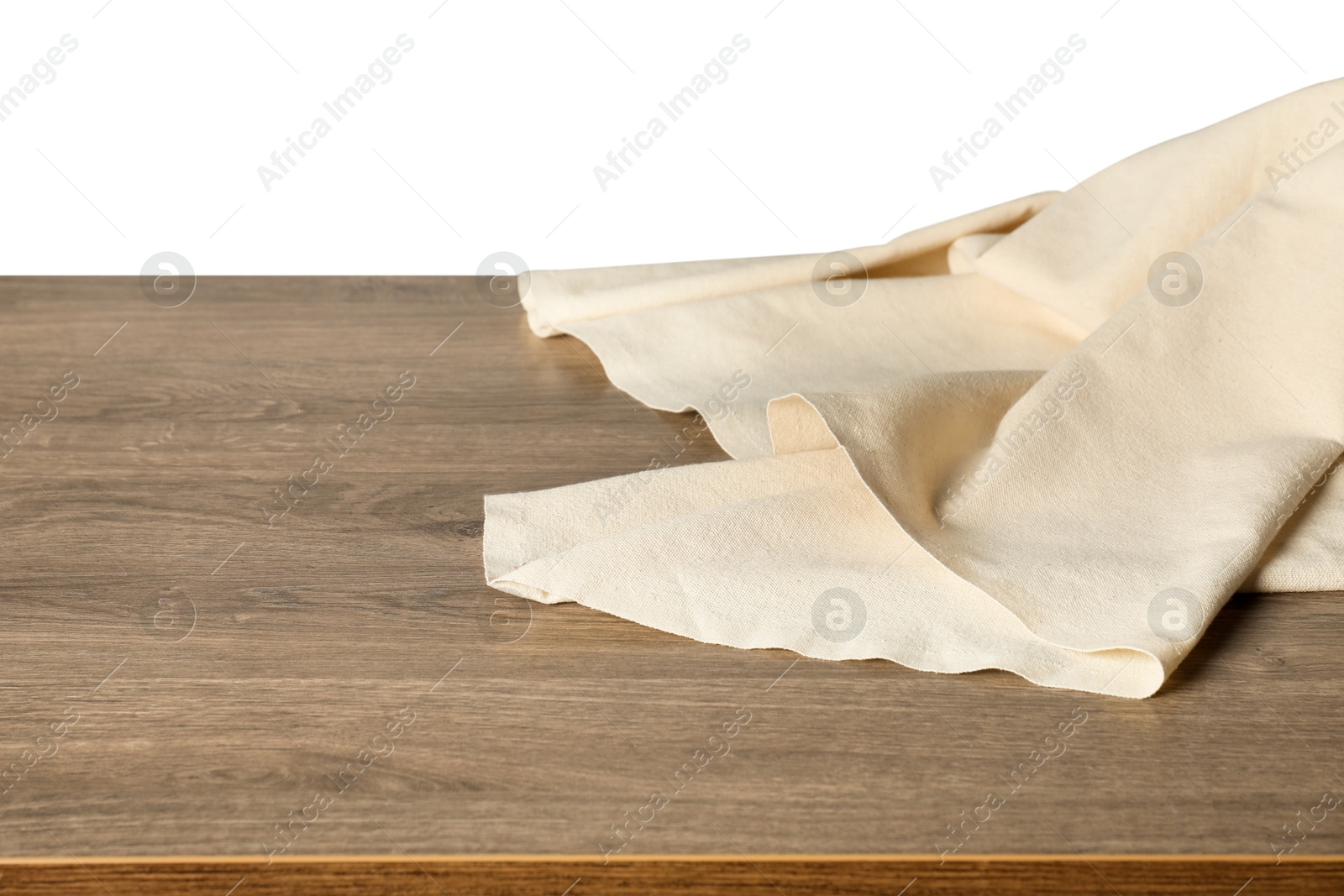 Photo of Beige tablecloth on wooden table against white background, closeup