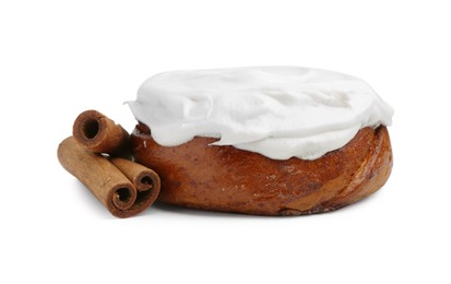 Photo of Tasty cinnamon roll with cream and spices isolated on white