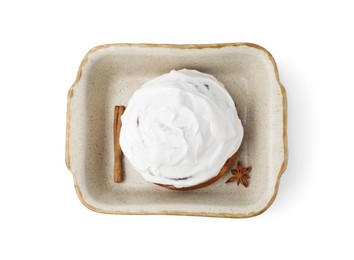 Photo of Tasty cinnamon roll with cream and spices in baking dish isolated on white, top view