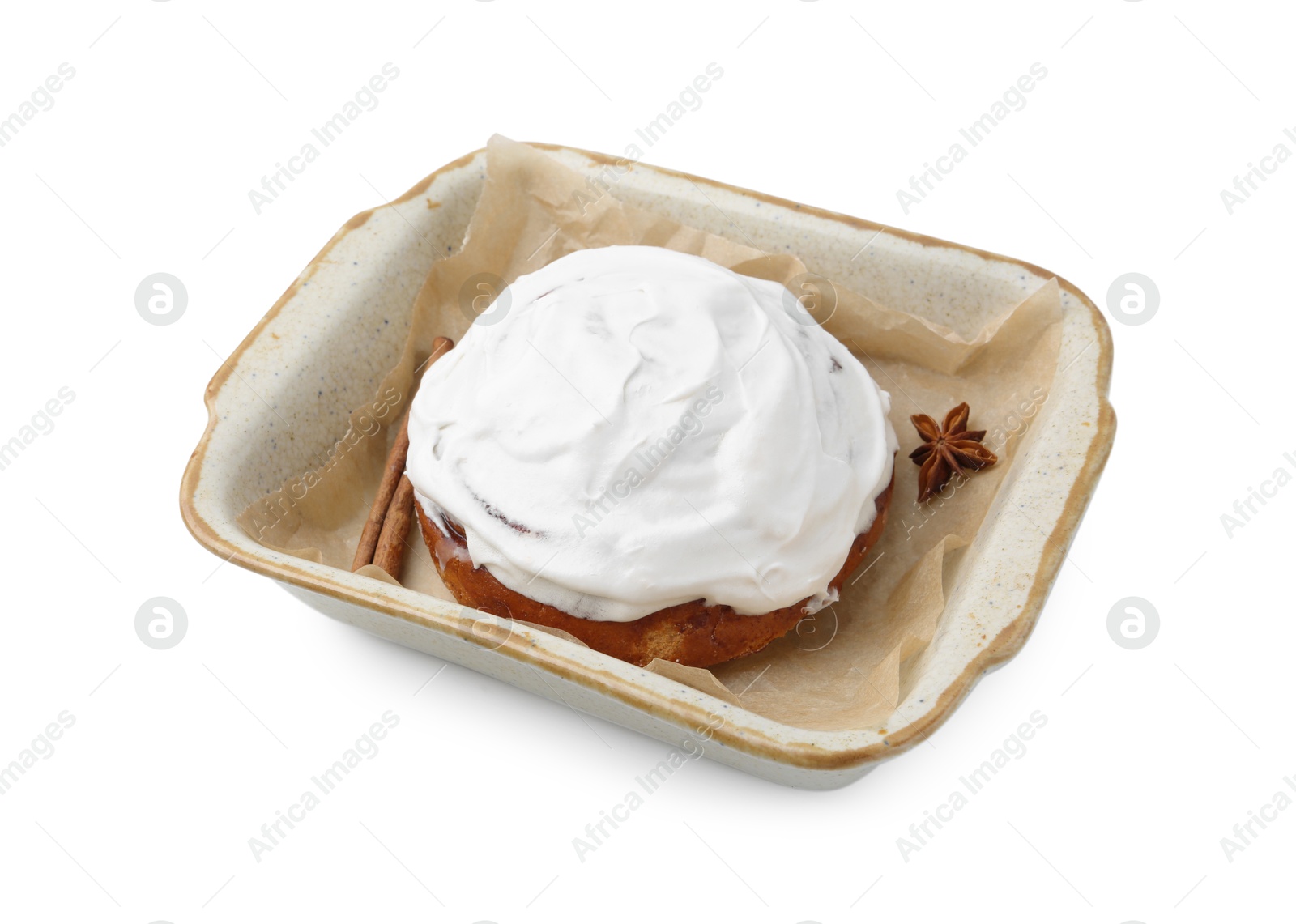 Photo of Tasty cinnamon roll with cream and spices in baking dish isolated on white