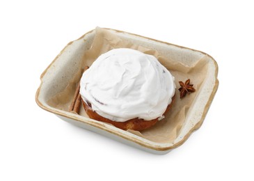 Photo of Tasty cinnamon roll with cream and spices in baking dish isolated on white