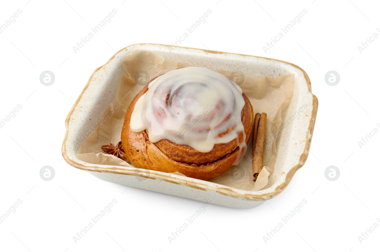 Photo of Tasty cinnamon roll with cream and spices in baking dish isolated on white