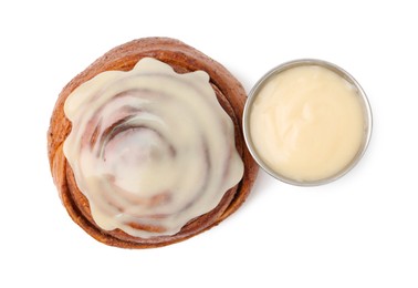 Photo of Tasty cinnamon roll with cream isolated on white, top view