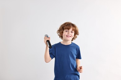 Photo of Little boy with microphone on light grey background